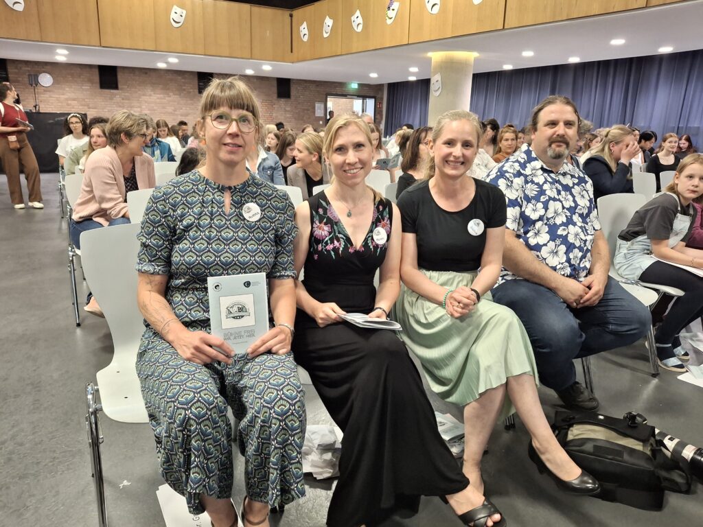 Das Orga-Team sitzt in der Aula in einer Reihe.
