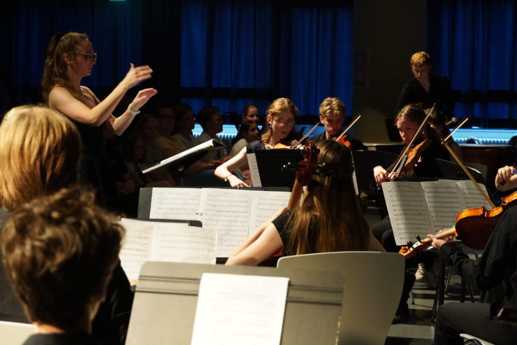 Frau Leinweber dirigiert das Orchester.