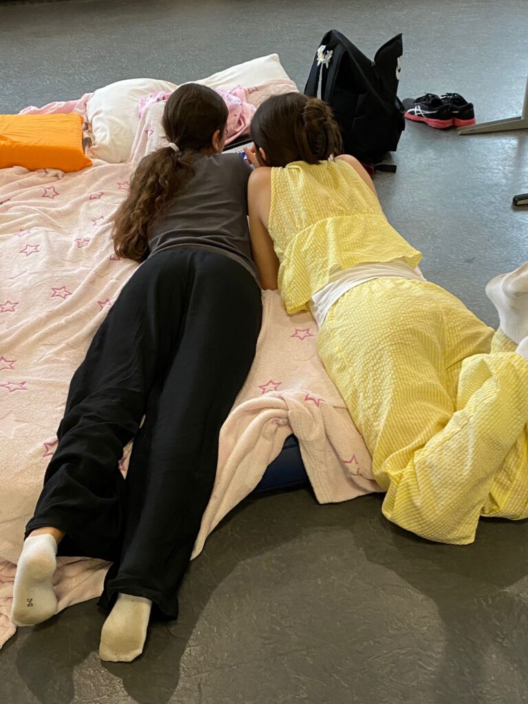 Schüler liegen auf Matratzen und unterhalten sich.