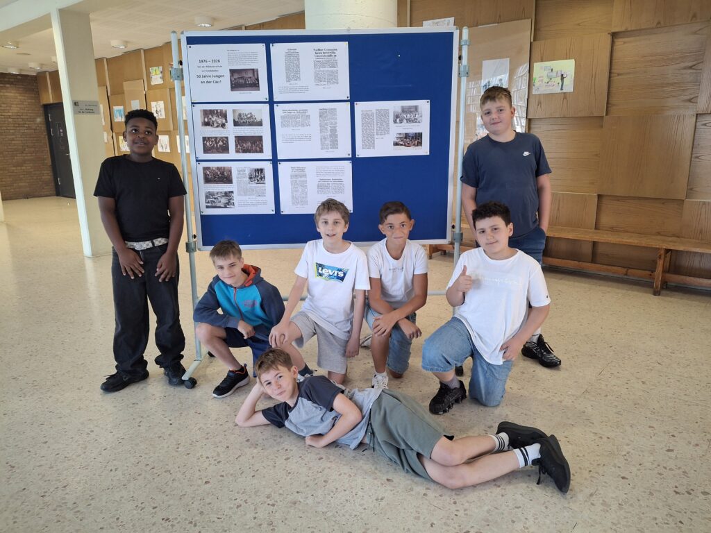 Eine Gruppe Jungen vor der Ausstellungsstellwand