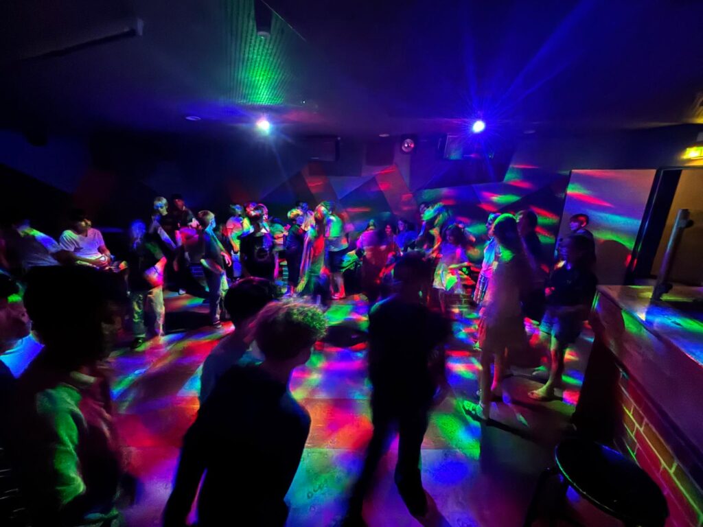 Schülerinnen und Schüler tanzen im Discokeller.