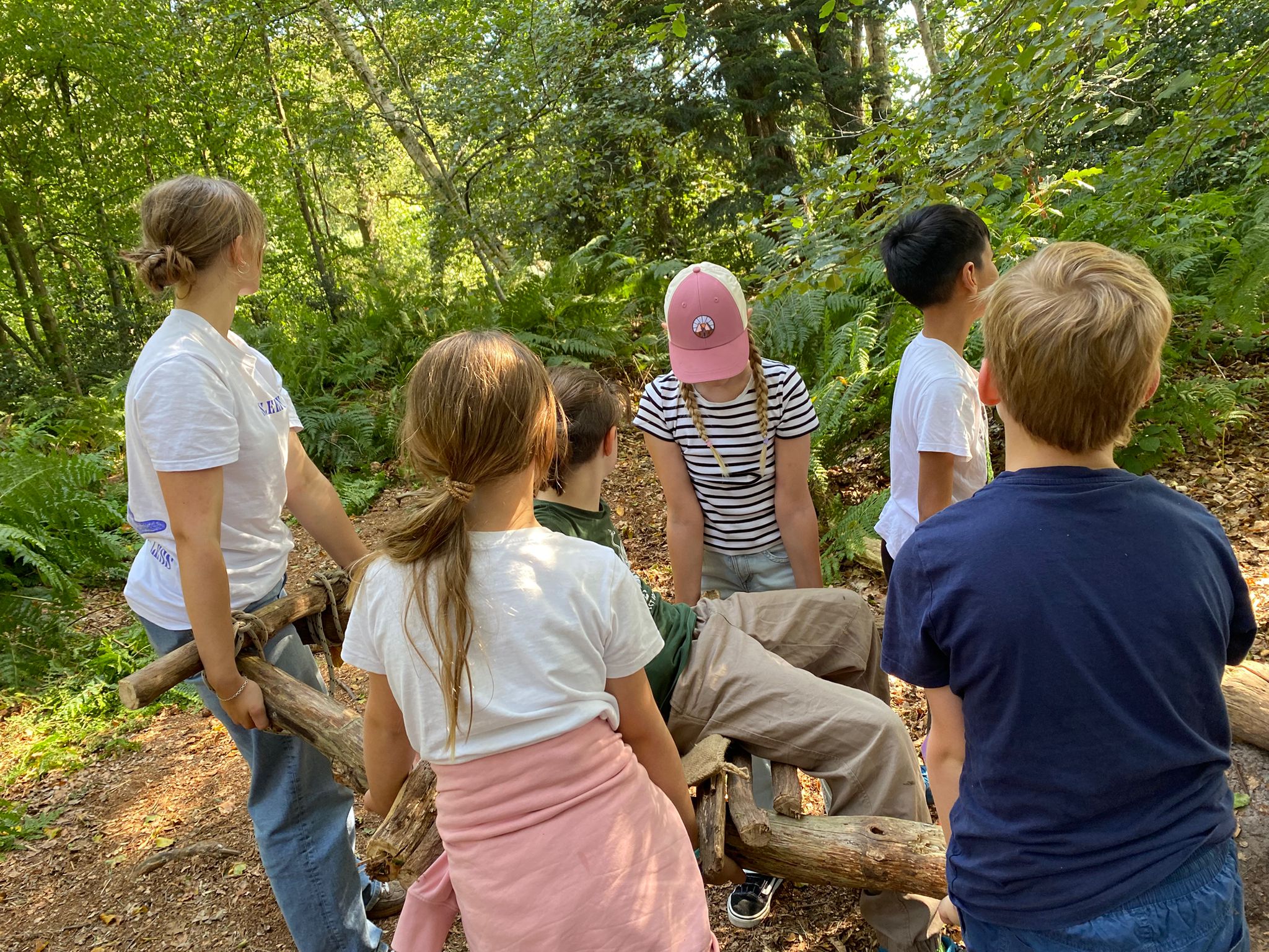 Schüler tragen eine selbstgebaute Sänfte.