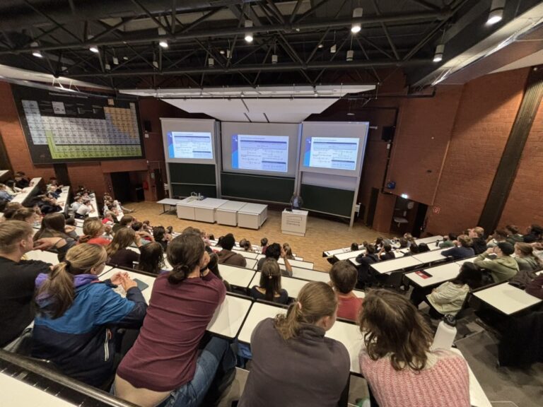 Schülerinnen und Schüler lauschen im Hörsaal der Vorlesung