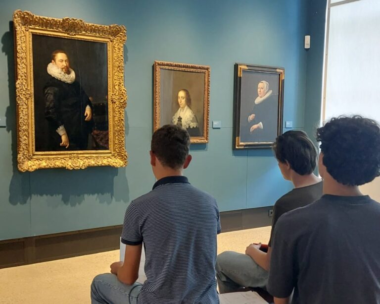 Schüler betrachten im Museum Gemälde