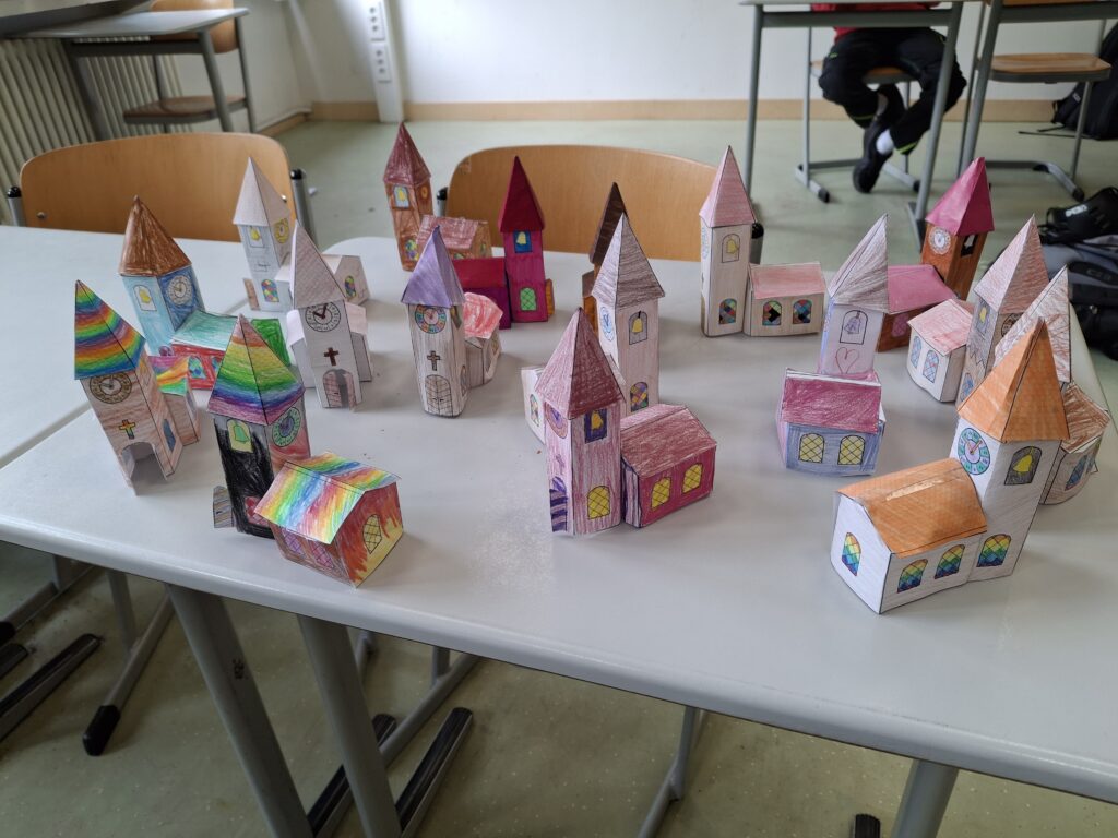 Verschiedene Kirchen aus Papier, bunt bemalt.